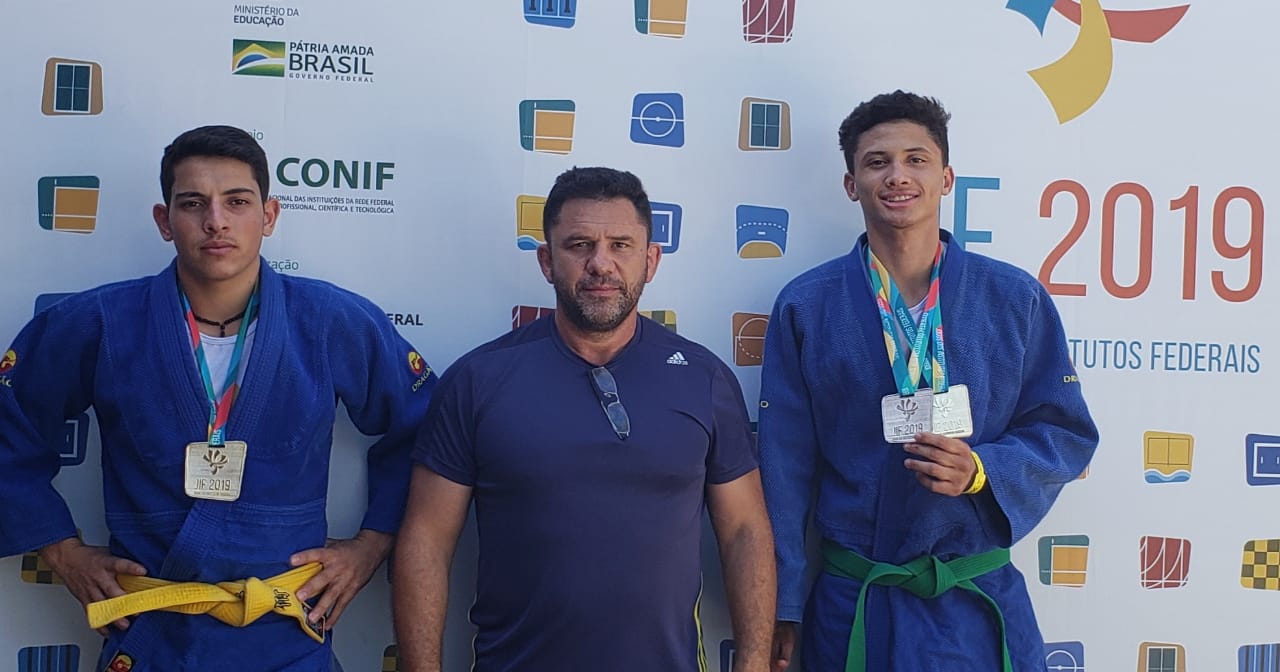 Dois judocas e o coordenador de esportes do IFSULDEMINAS mostram medalhas