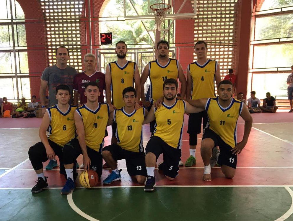 Todos uniformizados jogadores e equipe técnica do time de basquete do IFSULDEMINAS posam para foto na quadra